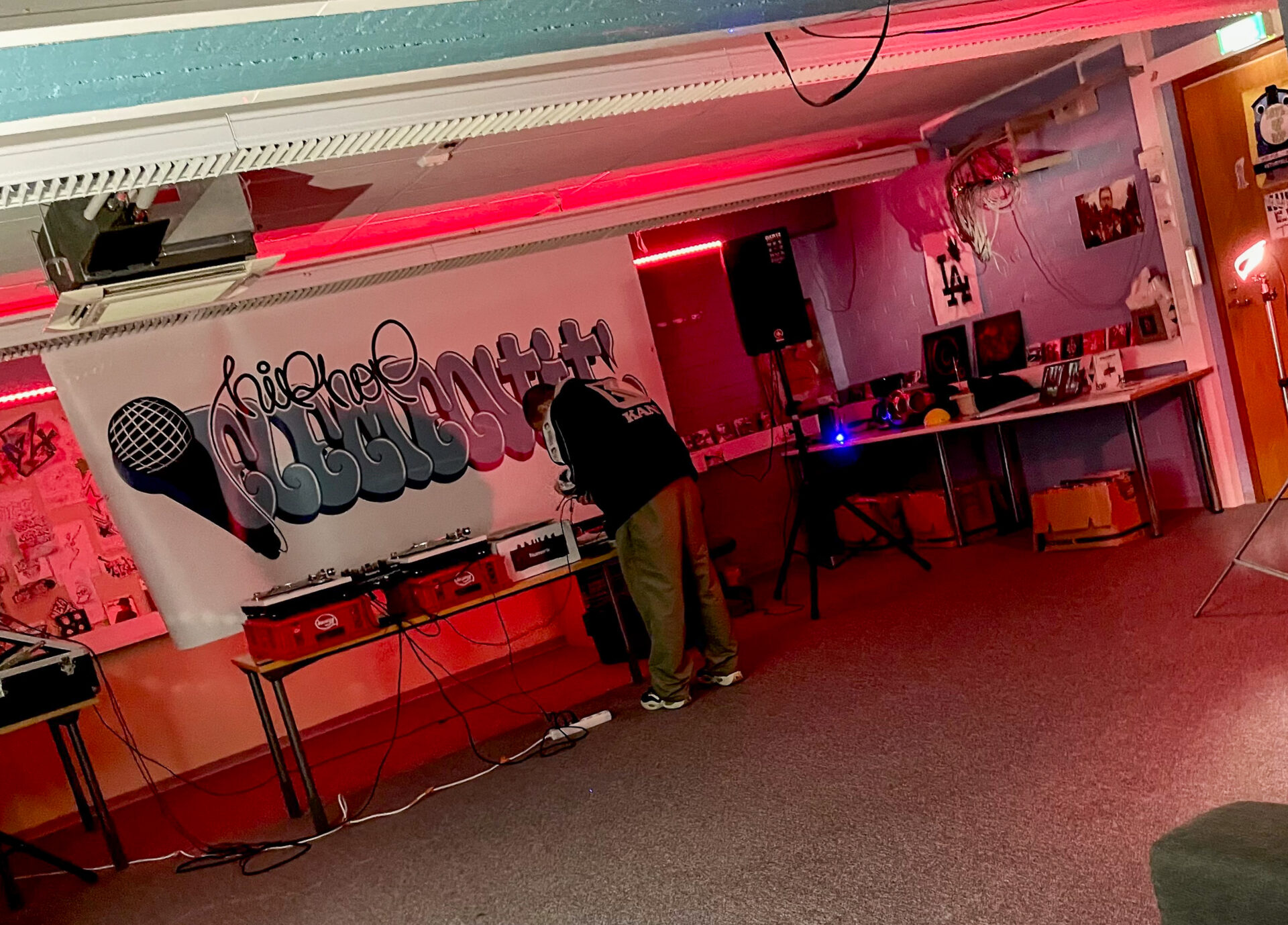 Opiskelija Hip hop -elementit -linjan luokassa. Luokassa laitteita ja seinillä alaan liittyviä julisteita ja materiaaleja.