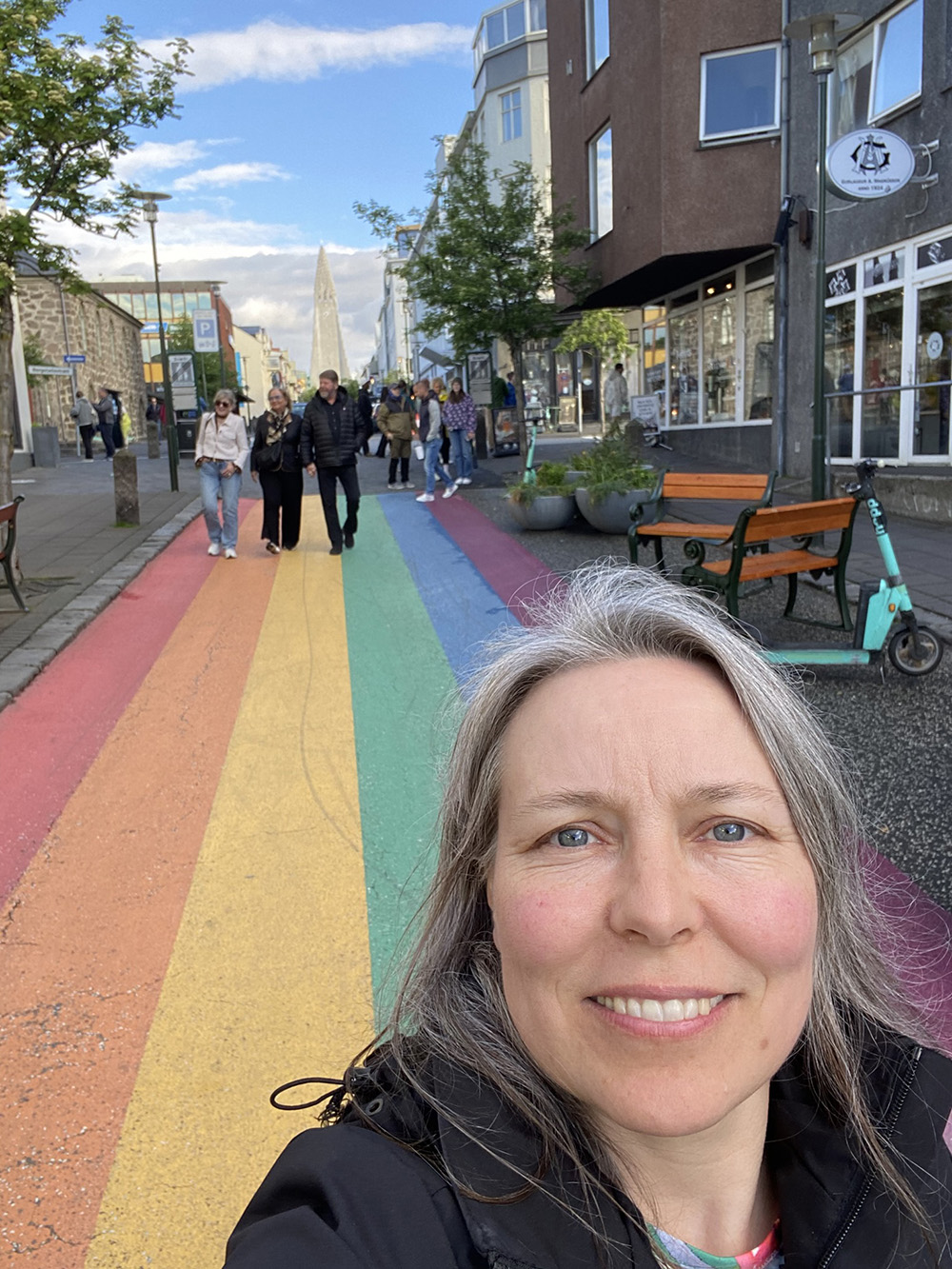 Reykjavikin katukuva, jossa sateenkaaren värinen katumaalaus. Kati kuvassa etulalla. Blogiteksti: Tutkimusretkeilyä Islannissa - Kokemuksia opettajien Erasmus+-kurssilta.
